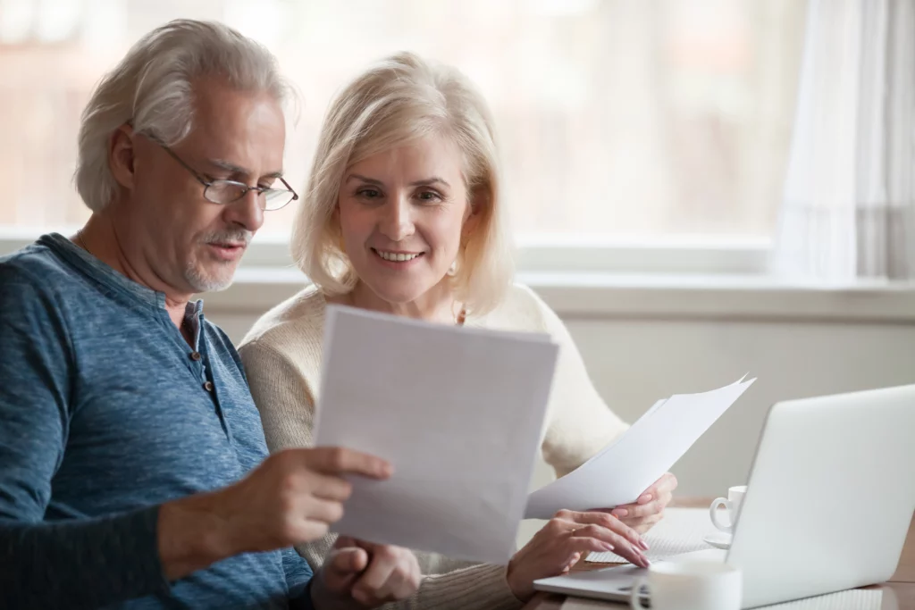 An older couple read through eligibility requirements to figure out how to get approved for a personal loan