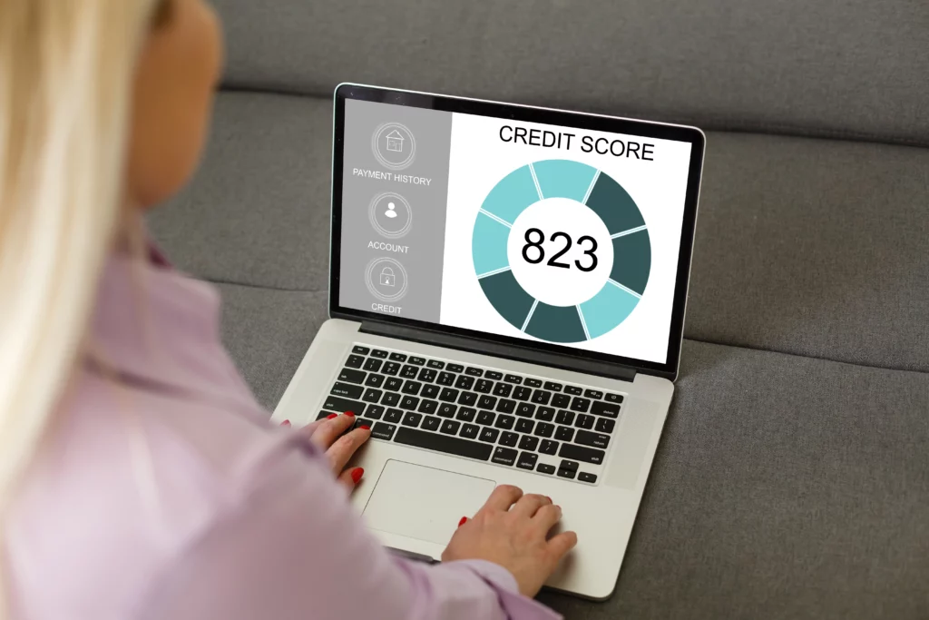 Close up of someone using a laptop, the screen displays a credit score of 823