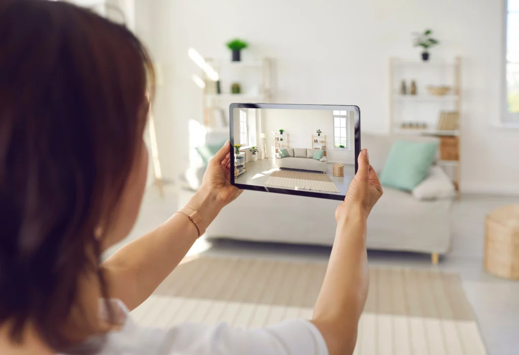 A woman takes a picture of her couch on an ipad so she can sell it online