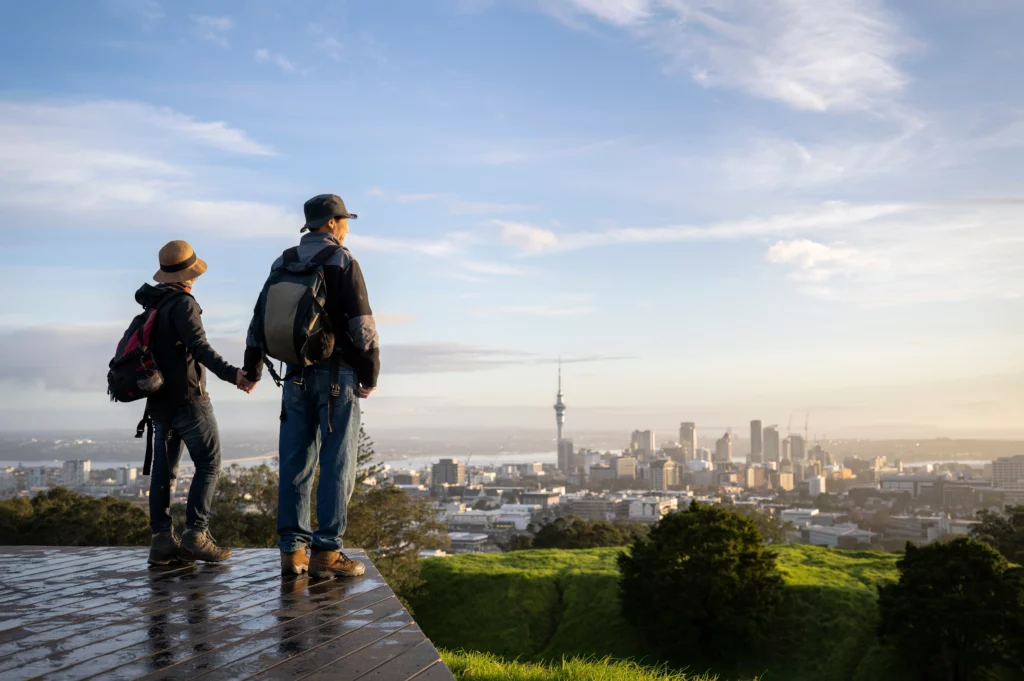 A couple look out at Auckland from the top of Mount Eden